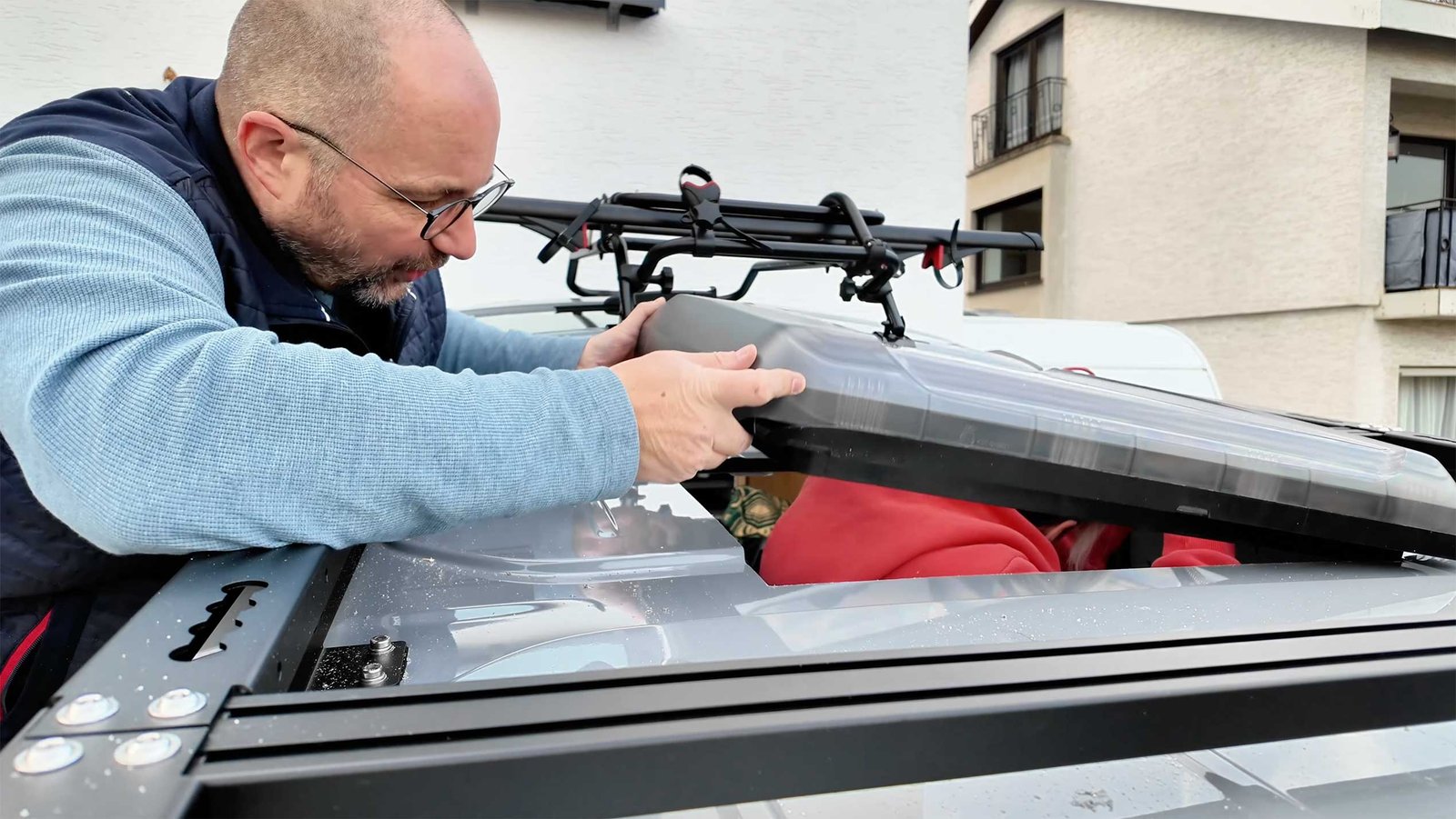 Mann arbeitet auf dem Fahrzeugdach am Fensterausschnitt